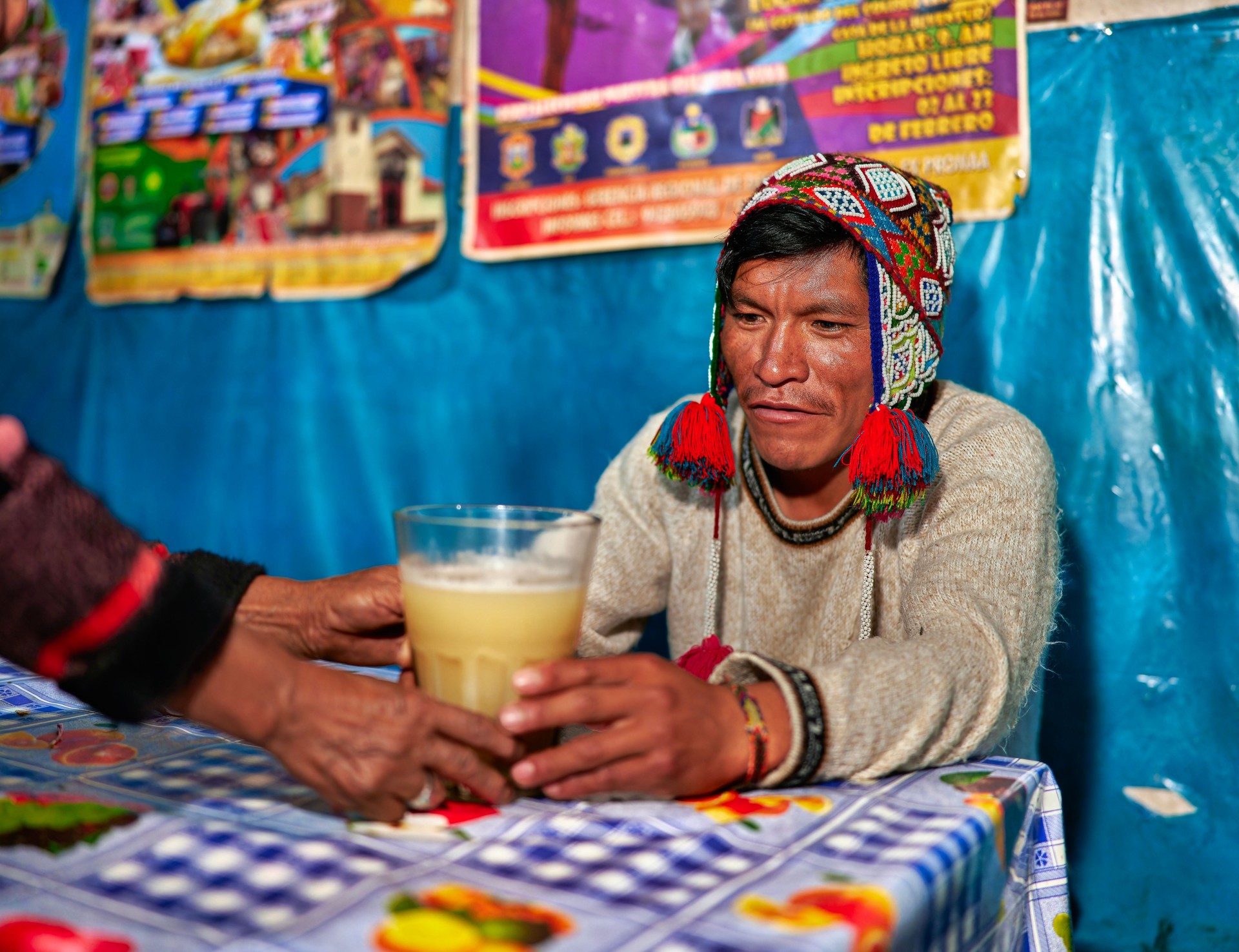 A Peruvian lady of the Quechua ethnic group serves the drink called chicha in a typical chicheria in Pisac in the Cusco region